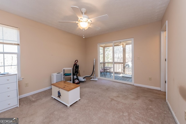 misc room featuring light colored carpet, a textured ceiling, and ceiling fan