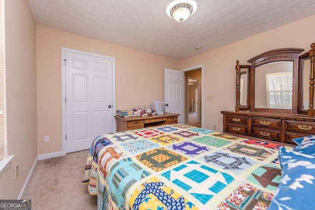 bedroom featuring light colored carpet and a textured ceiling