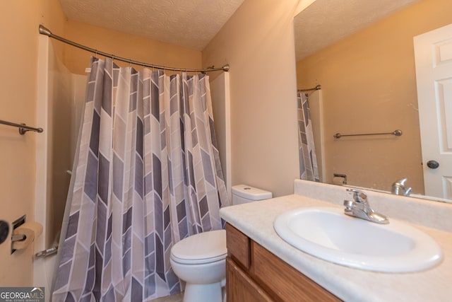 bathroom with vanity, toilet, a textured ceiling, and walk in shower