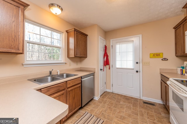 kitchen with sink, stainless steel dishwasher, a textured ceiling, and electric stove