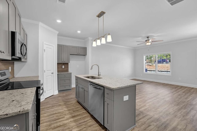 kitchen featuring sink, gray cabinetry, decorative light fixtures, a center island with sink, and stainless steel appliances