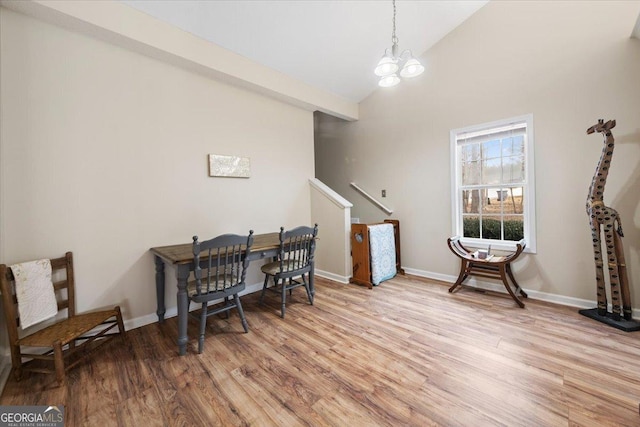 dining room with a chandelier, high vaulted ceiling, and light wood-type flooring