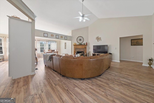 living room featuring hardwood / wood-style flooring, ceiling fan, and high vaulted ceiling