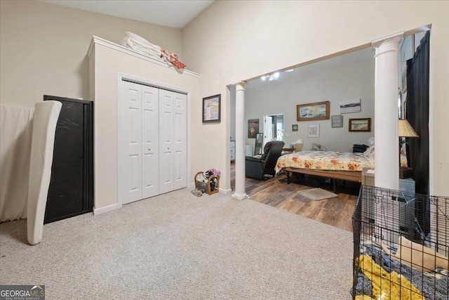 bedroom featuring a closet, a towering ceiling, decorative columns, and carpet