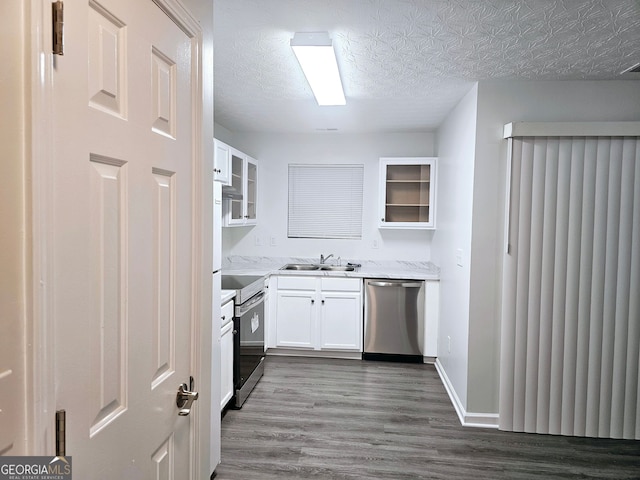 kitchen with appliances with stainless steel finishes, dark hardwood / wood-style floors, sink, white cabinets, and a textured ceiling