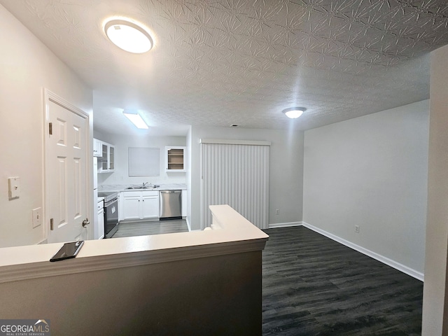 kitchen featuring sink, stainless steel appliances, white cabinets, dark hardwood / wood-style flooring, and kitchen peninsula