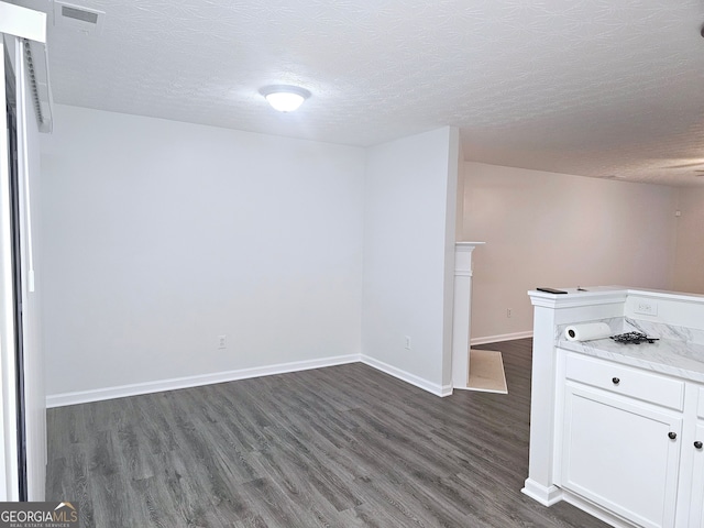 interior space with dark wood-type flooring and a textured ceiling