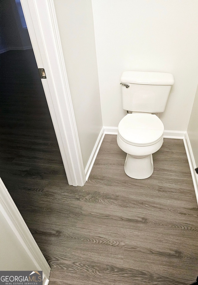 bathroom featuring wood-type flooring and toilet