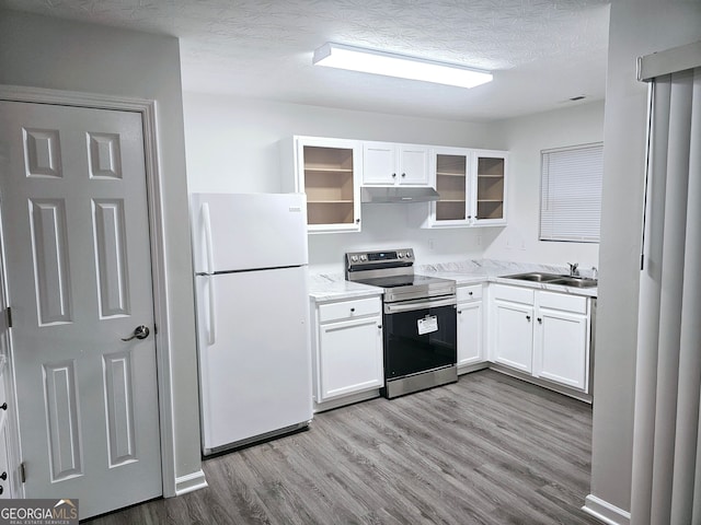 kitchen with sink, stainless steel range with electric cooktop, white refrigerator, light hardwood / wood-style floors, and white cabinets