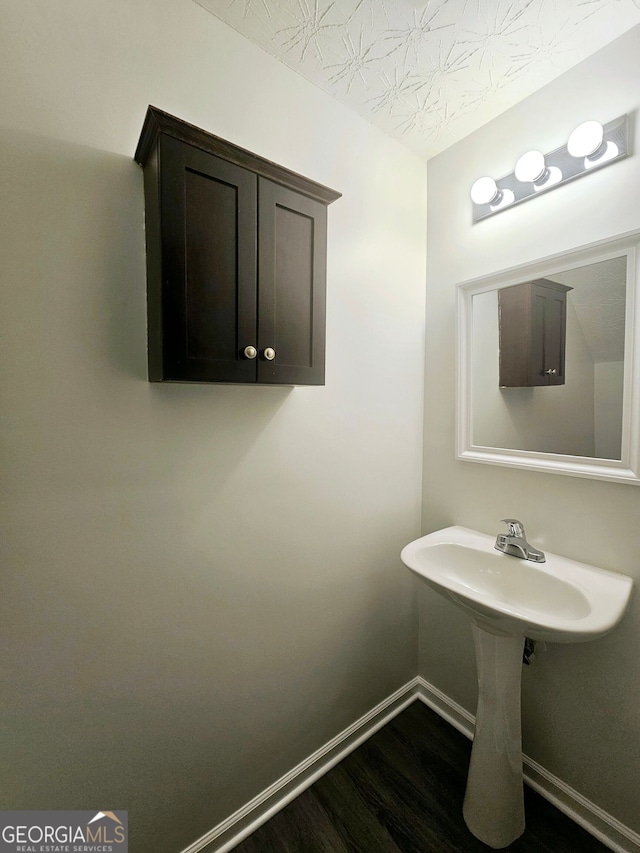 bathroom featuring wood-type flooring and a textured ceiling