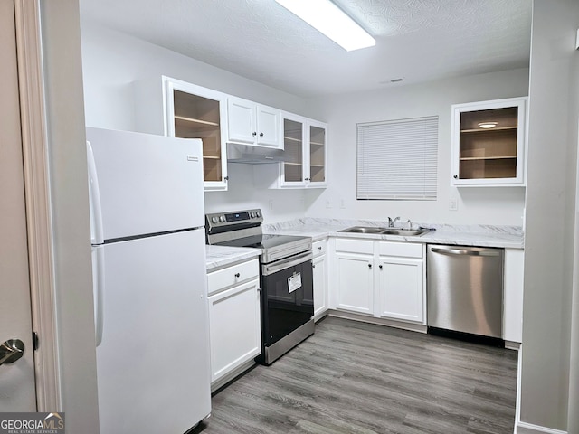 kitchen featuring white cabinetry, appliances with stainless steel finishes, sink, and hardwood / wood-style flooring