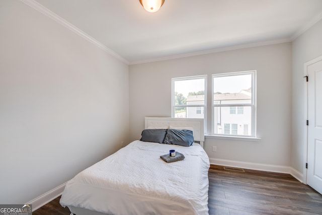 bedroom featuring ornamental molding and dark hardwood / wood-style flooring