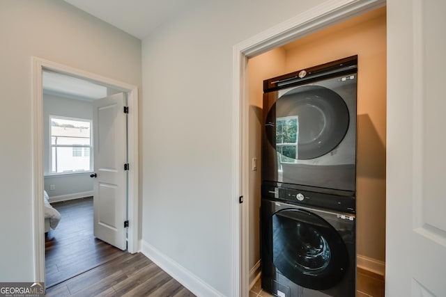 washroom featuring stacked washer and dryer and dark hardwood / wood-style floors