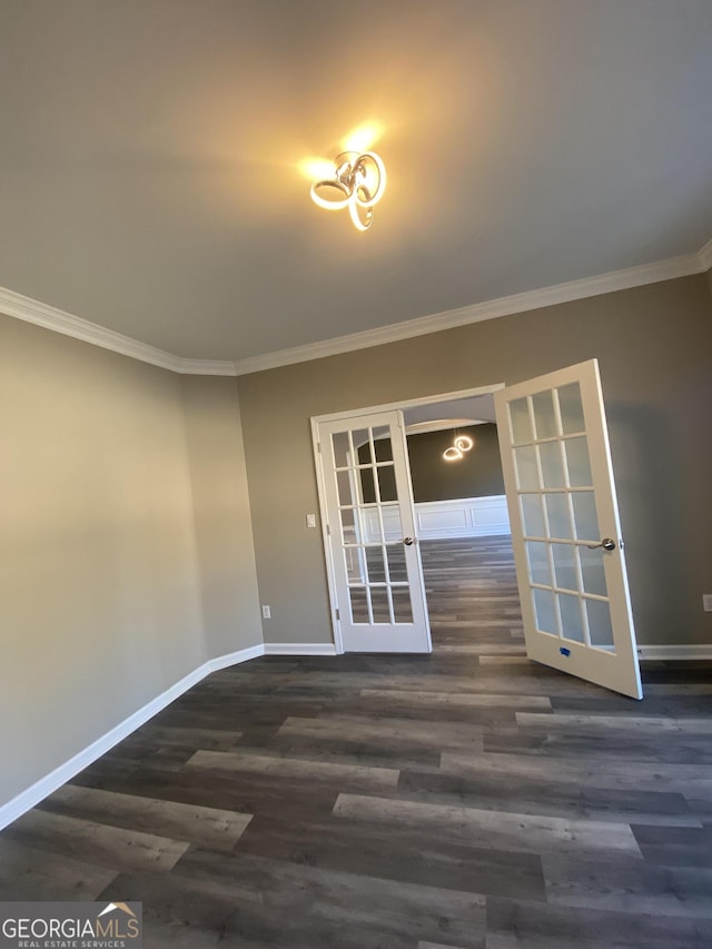 empty room with french doors, ornamental molding, and dark wood-type flooring