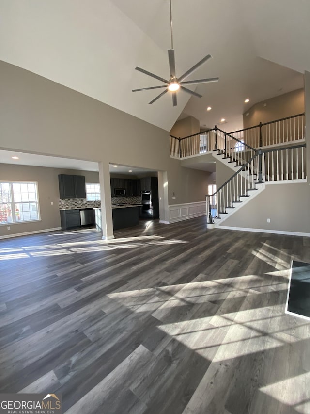 unfurnished living room featuring ceiling fan, dark hardwood / wood-style flooring, and high vaulted ceiling