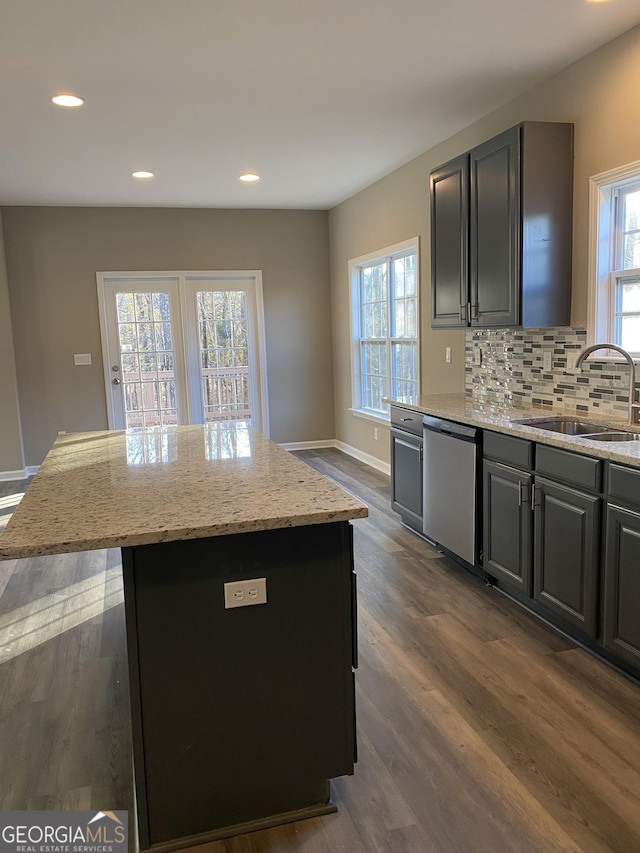 kitchen with dishwasher, a kitchen island, and sink