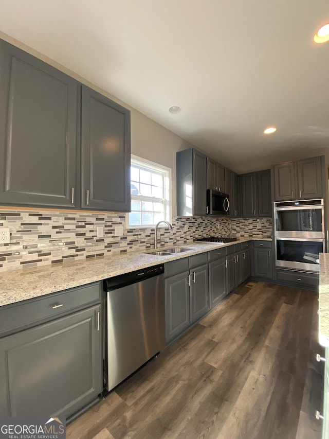 kitchen with gray cabinetry, sink, decorative backsplash, and appliances with stainless steel finishes