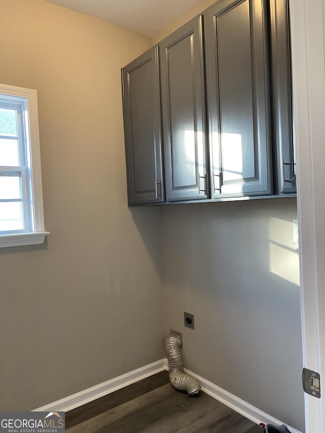 washroom featuring dark hardwood / wood-style floors, cabinets, and hookup for an electric dryer