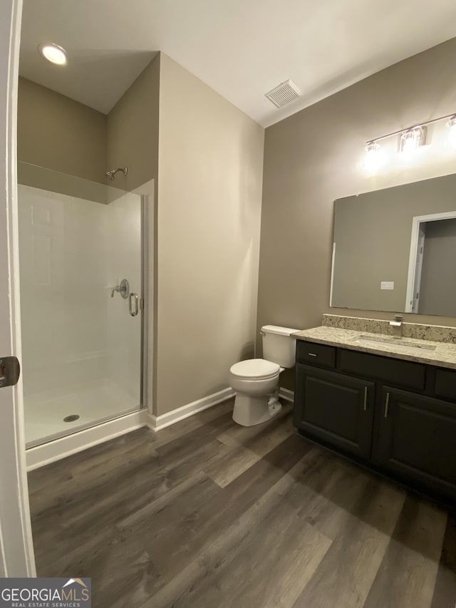 bathroom with hardwood / wood-style flooring, vanity, and a shower