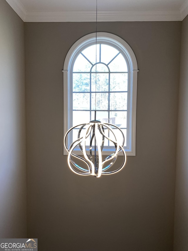 interior details with an inviting chandelier and crown molding