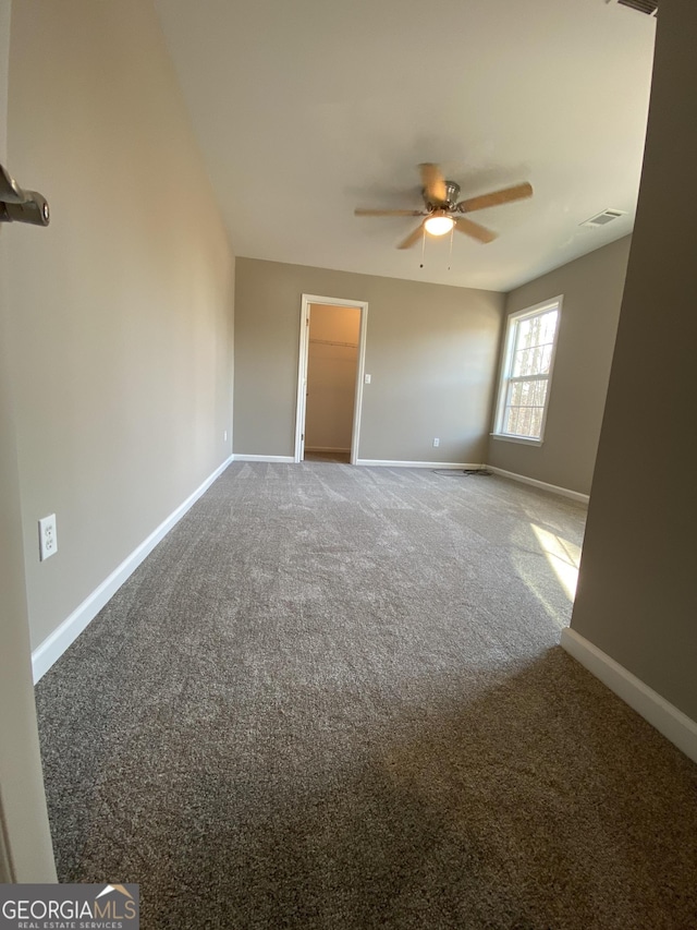 unfurnished room featuring ceiling fan and carpet