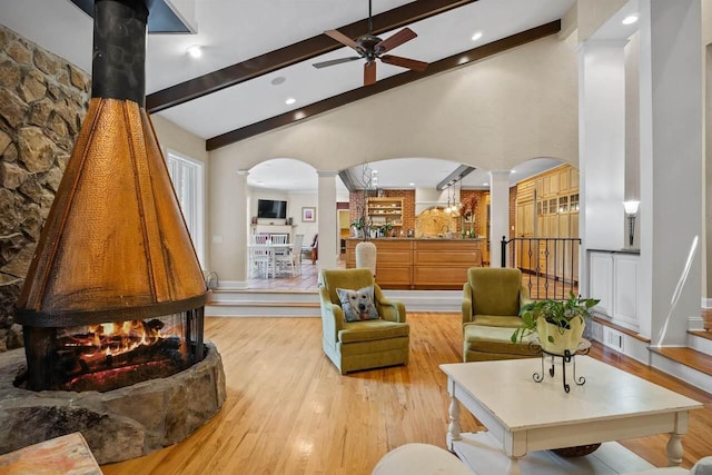 sitting room featuring ornate columns, high vaulted ceiling, light wood-type flooring, beamed ceiling, and ceiling fan