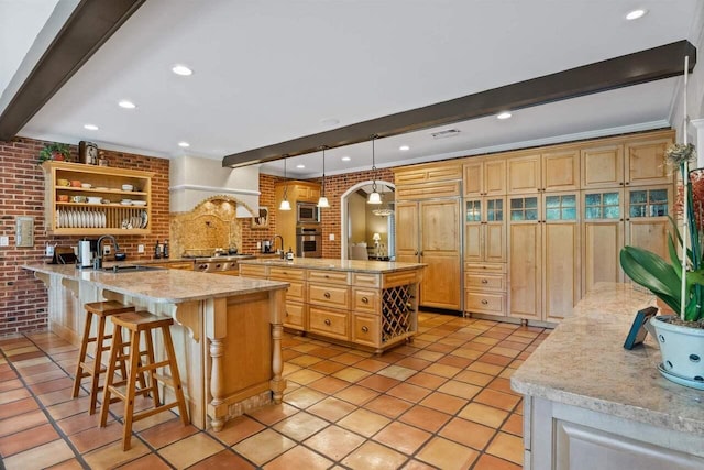 kitchen with premium range hood, appliances with stainless steel finishes, pendant lighting, sink, and kitchen peninsula