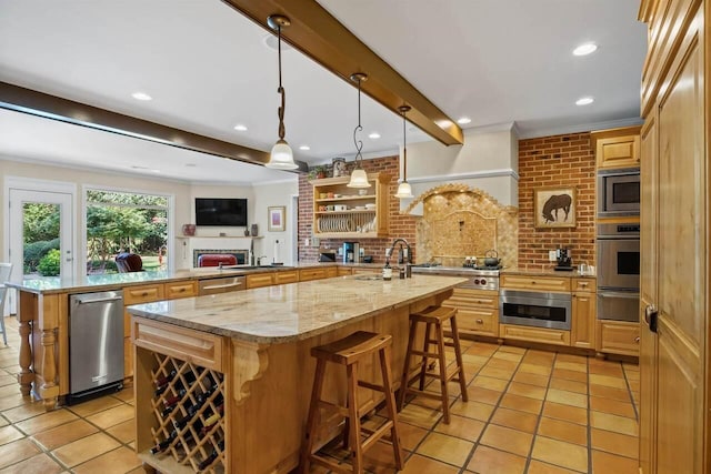 kitchen with hanging light fixtures, a center island with sink, stainless steel appliances, a kitchen bar, and beamed ceiling