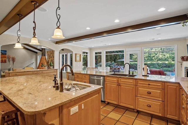 kitchen with hanging light fixtures, dishwasher, sink, and a center island with sink