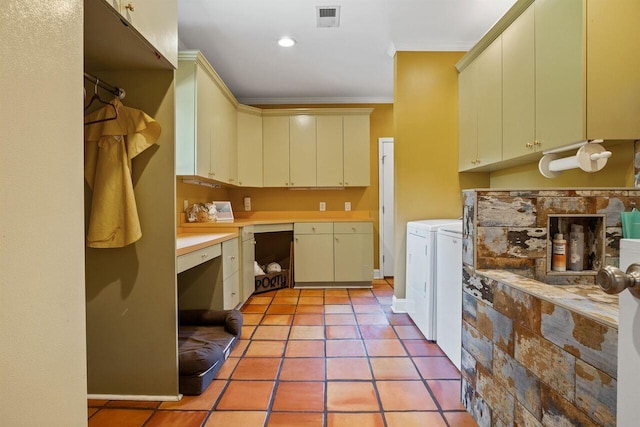 kitchen featuring ornamental molding, cream cabinets, and washing machine and dryer