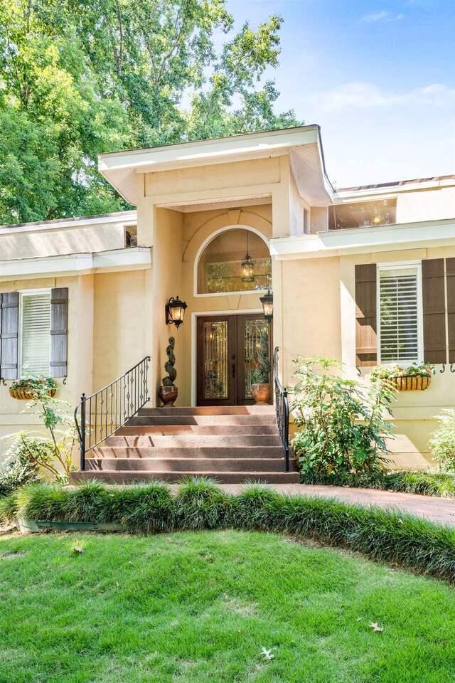 view of exterior entry featuring french doors and a yard