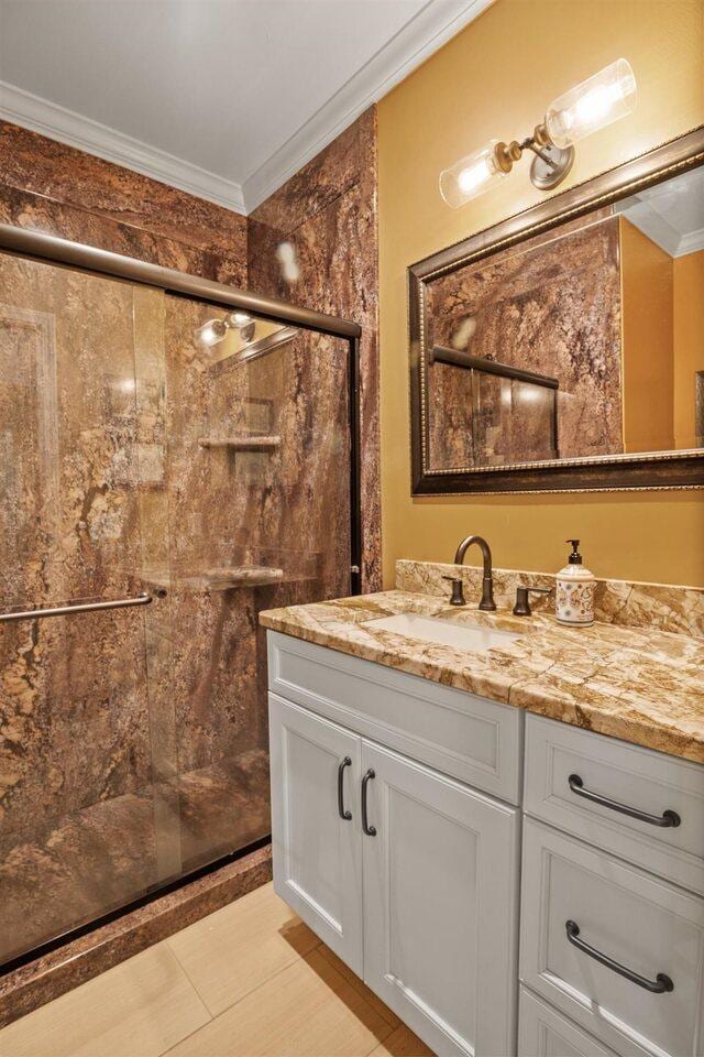 bathroom with ornamental molding, a shower with door, and vanity