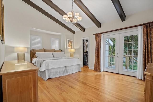 bedroom with vaulted ceiling with beams, a walk in closet, access to outside, light wood-type flooring, and french doors