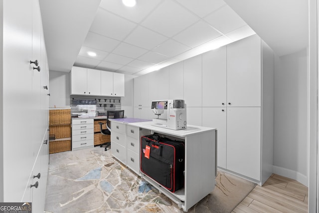 kitchen featuring white cabinetry and a paneled ceiling