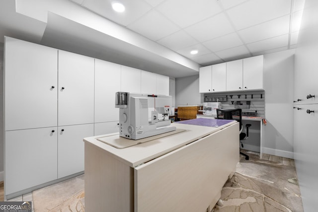 kitchen with a center island, a drop ceiling, decorative backsplash, and white cabinets