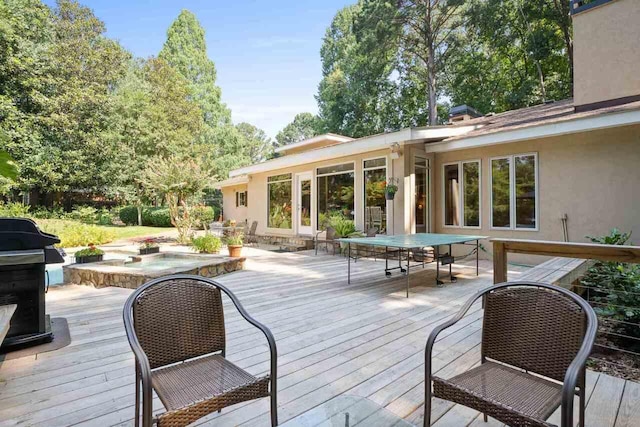 wooden deck with area for grilling and a swimming pool