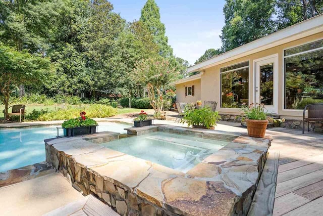 view of swimming pool with a wooden deck and an in ground hot tub