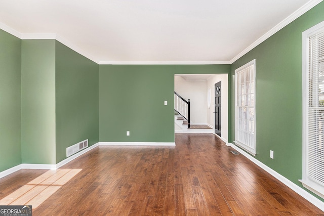 empty room featuring ornamental molding and wood-type flooring