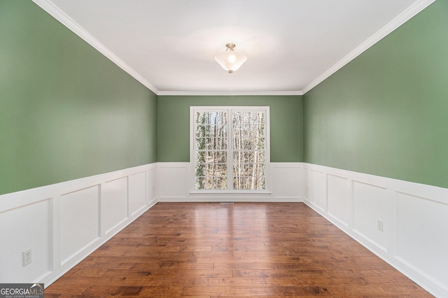 spare room with ornamental molding and dark hardwood / wood-style floors