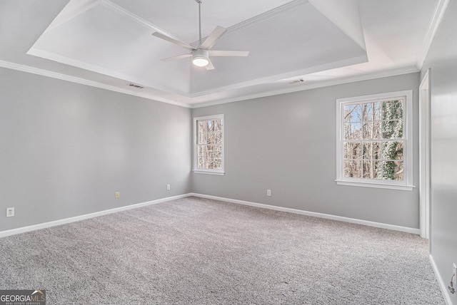 empty room with crown molding, carpet floors, a raised ceiling, and ceiling fan