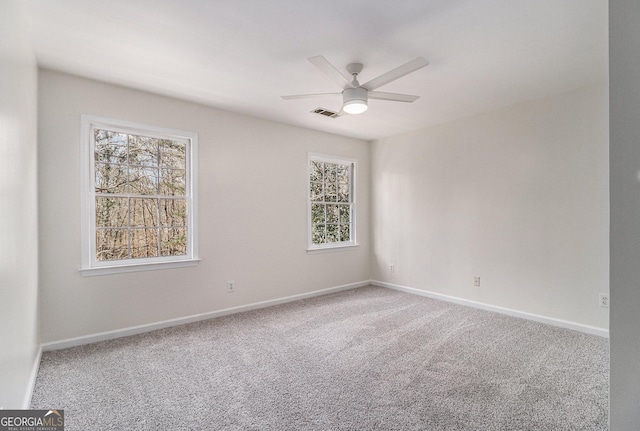 carpeted spare room featuring ceiling fan