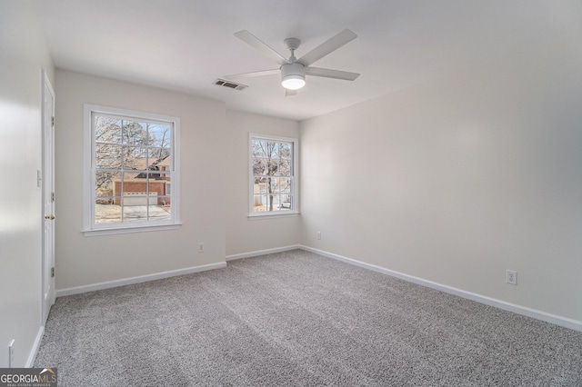 carpeted spare room with ceiling fan