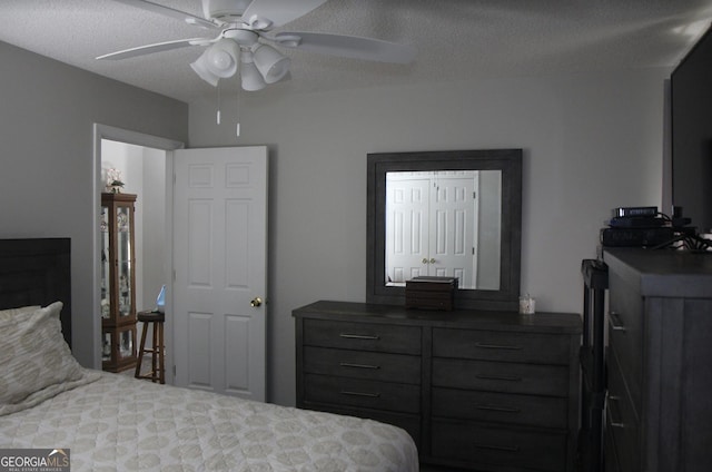 bedroom featuring ceiling fan and a textured ceiling