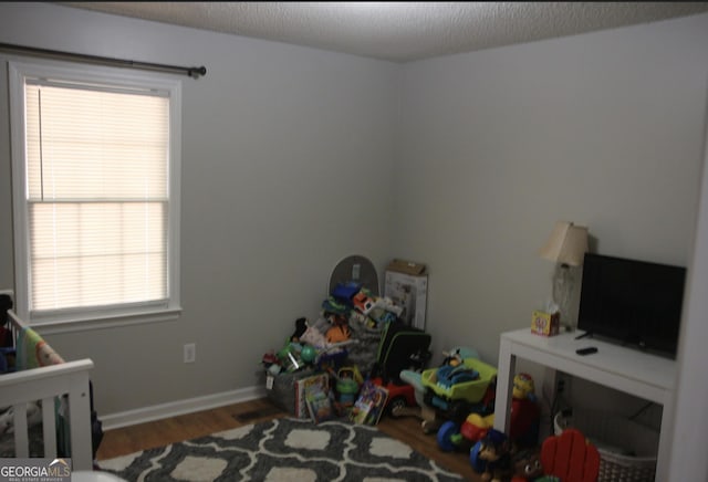 bedroom with hardwood / wood-style flooring and a textured ceiling