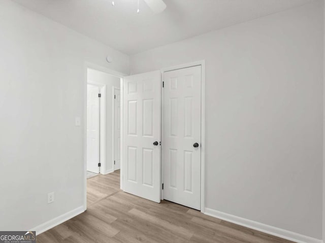 unfurnished bedroom with ceiling fan and light hardwood / wood-style flooring