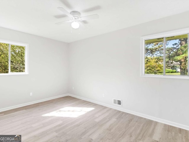 unfurnished room featuring ceiling fan, a healthy amount of sunlight, and light hardwood / wood-style floors