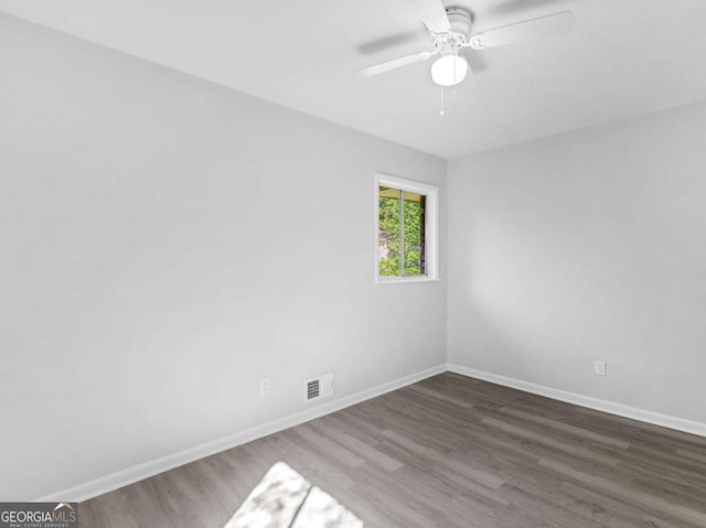 unfurnished room featuring dark wood-type flooring and ceiling fan