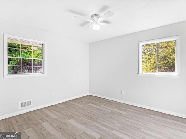 empty room with light hardwood / wood-style flooring, a wealth of natural light, and ceiling fan