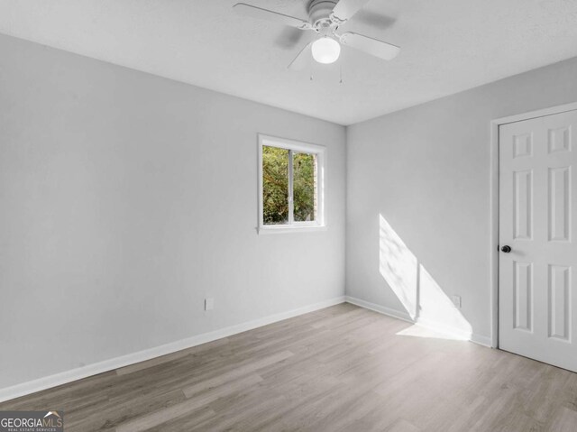 unfurnished room with ceiling fan and light wood-type flooring