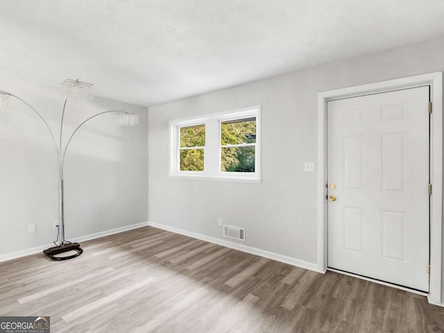 interior space featuring light hardwood / wood-style floors and a textured ceiling